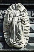 Скульптура богородиці з немовлям над…