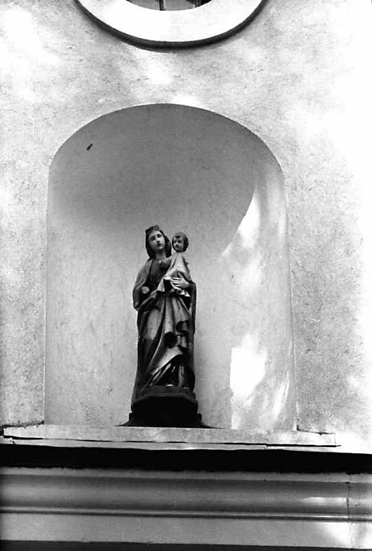 Скульптура богородиці з немовлям у ніші